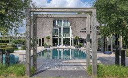 Blick vom Garten auf den Pool und das dahinterliegende Wohnhaus.