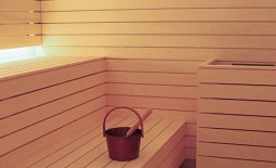 Der Saunainnenraum mit Massivholzlamellen und indirekter Beleuchtung der Rückenlehnen.