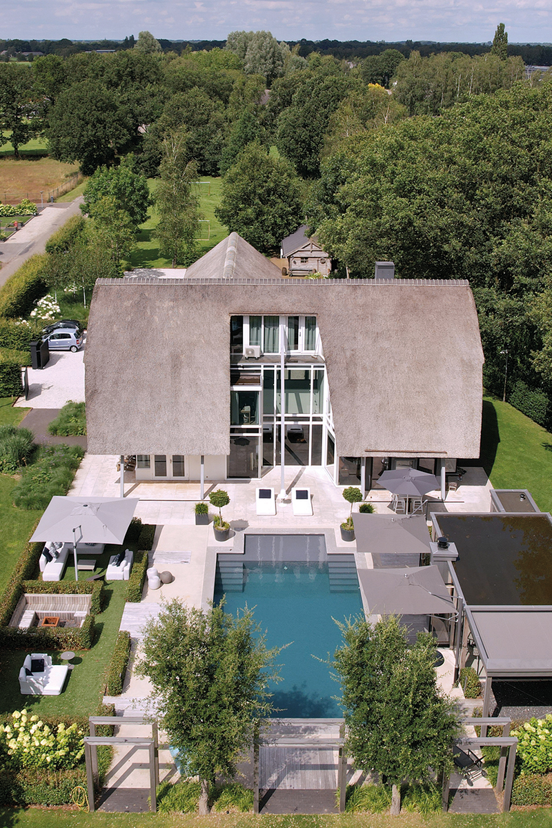 Blick von oben auf das Wohnhaus und den davor liegenden Pool.