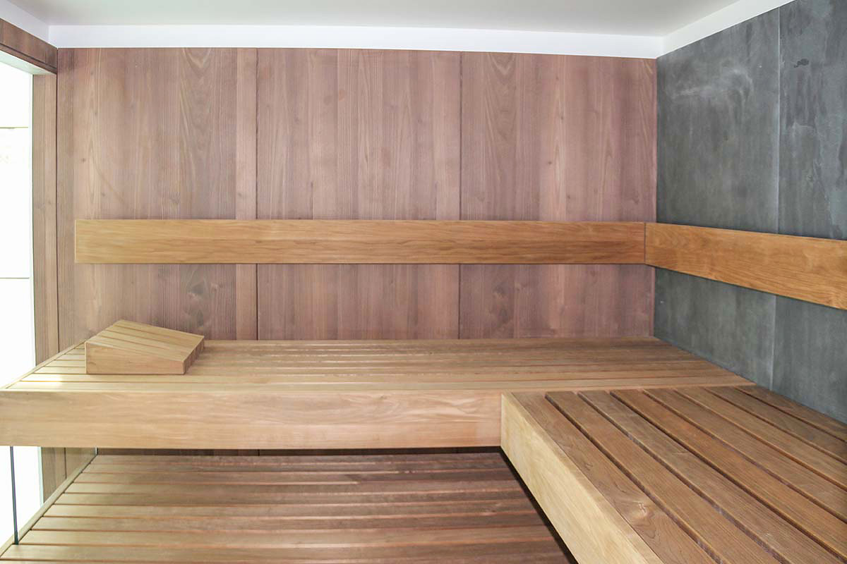 Saunainnenraum, verkleidet mit Wandboards und Echtsteinplatte.