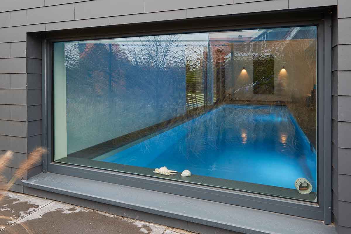 Außenaufnahme eines Indoor-Pools durch ein Fenster hindurch.