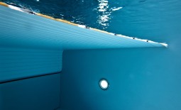 Eine Unterwasseraufnahme, die einen eingeschalteten LED-Scheinwerfer im Schwimmbecken zeigt.